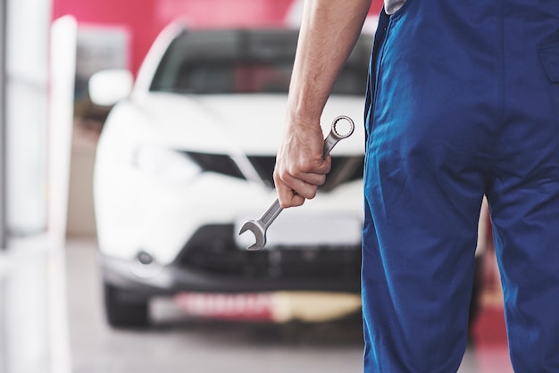 Hand of car mechanic with wrench.