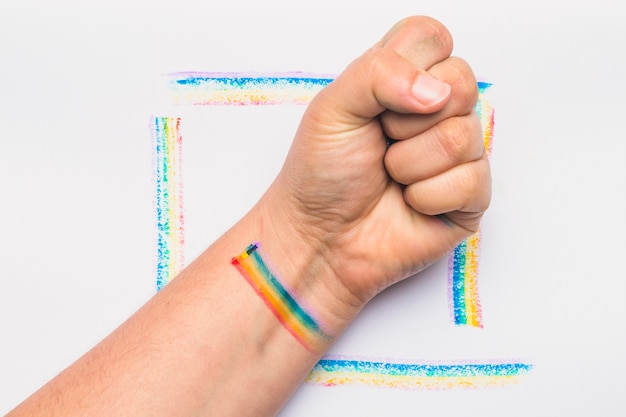 Hand clenched into fist with stripes in LGBT colors