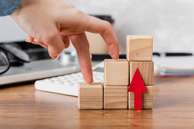 Free photo hand climbing wooden blocks to represent growth