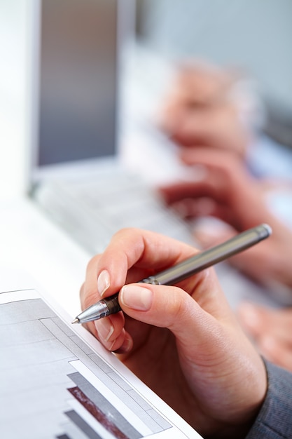 Hand close-up of executive writing in a meeting