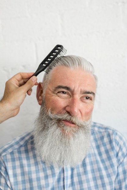 Free photo hand combing old man gray hair