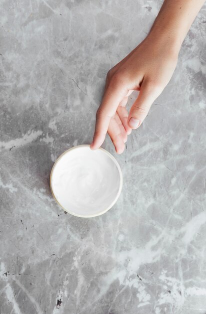 Photo Female hands in a paraffin wax bowl