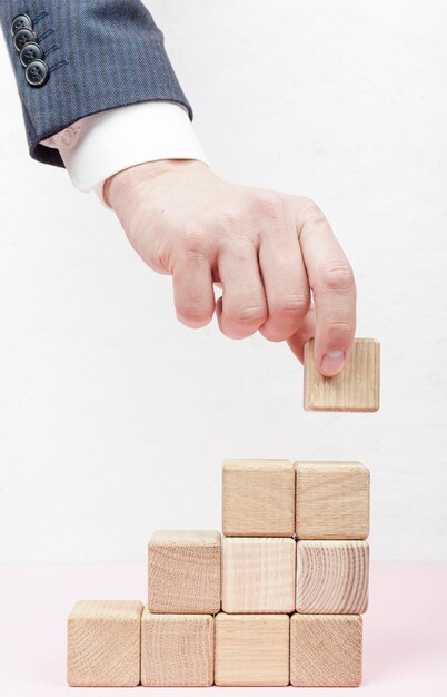 Hand creating stairs from wooden cubes