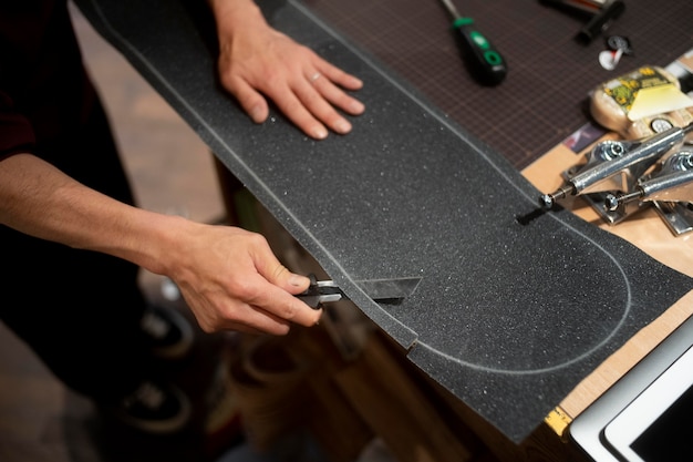 Hand cutting grip tape with knife close up