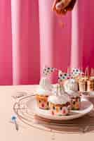 Бесплатное фото Ручное украшение кексов разноцветной посыпкой