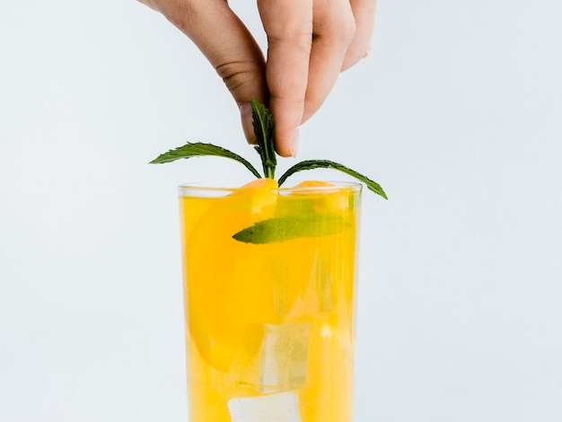 Hand decorating drink with mint leaf