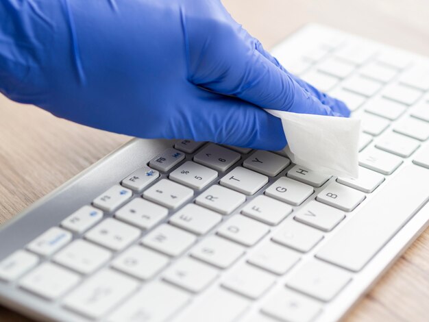 Hand disinfecting keyboard surface with napkin