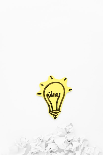 Free photo hand drawn idea light bulb with crumpled paper on white background