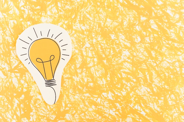 Hand drawn light bulb cut out over the yellow pattern background