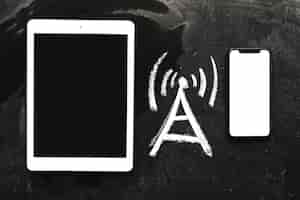 Free photo hand drawn network signal icon between the digital tablet and cellphone on chalkboard