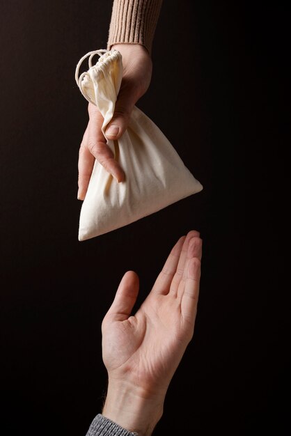 Hand giving bag with grains