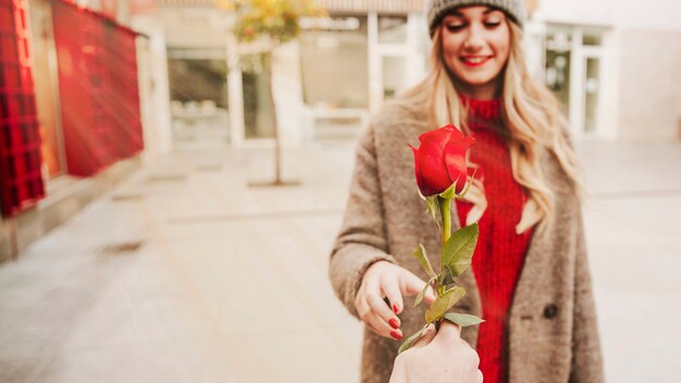 Hand giving rose to woman