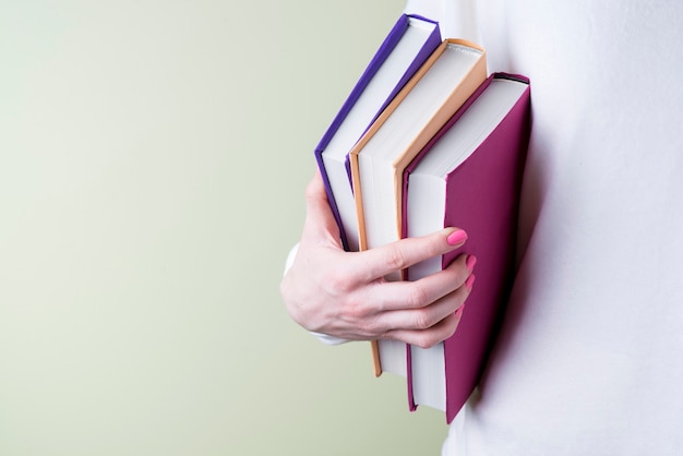 Hand grabbing some books with different colors