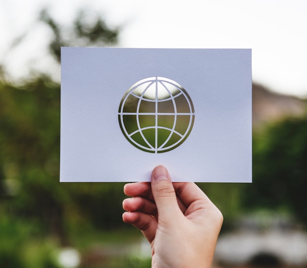 Foto gratuita carta del globo della tenuta della mano che scolpisce con il fondo della natura