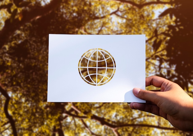 Free photo hand hold globe paper carving with nature background