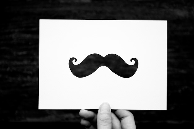 Free photo hand hold mustache paper carving