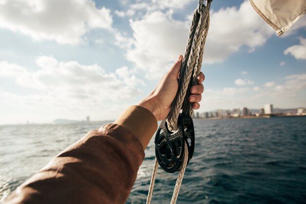 Hand hold onto sail or rope on yacht