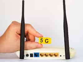 Free photo hand holding 5g snap cubes above router