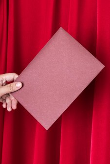 Рука держит розовый конверт карты Premium Фотографии
