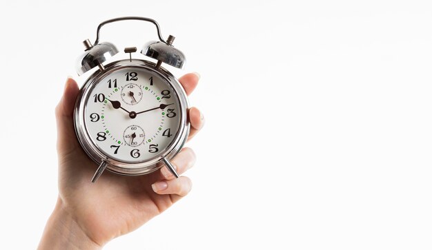 Hand holding alarm clock with copy space