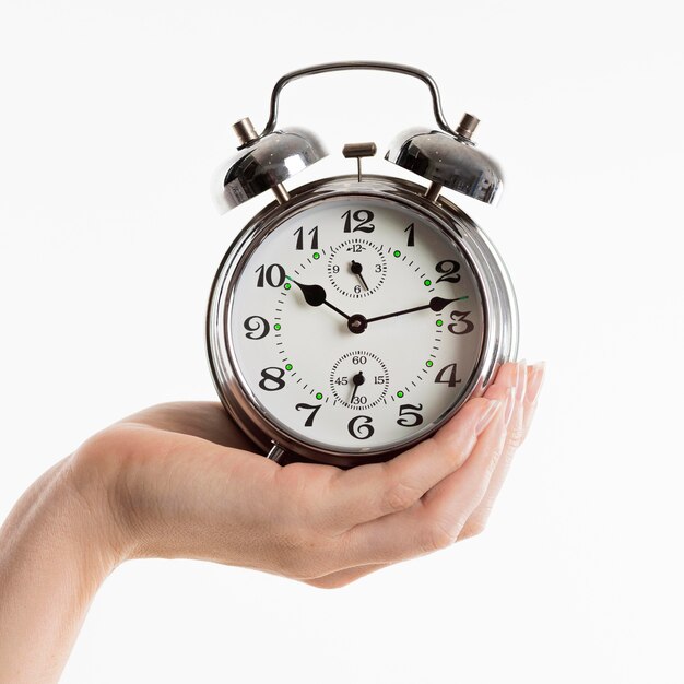 Hand holding alarm clock