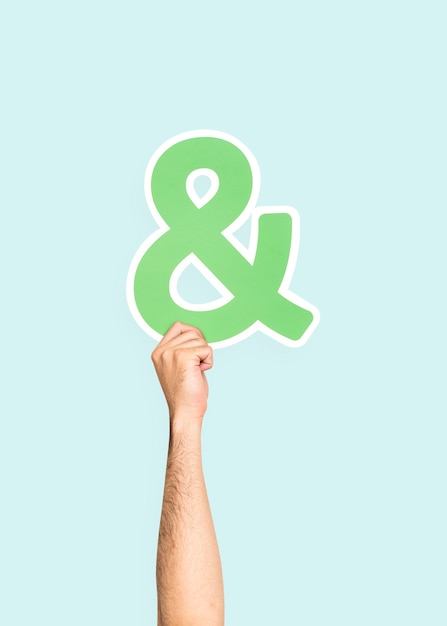 Free photo hand holding ampersand symbol