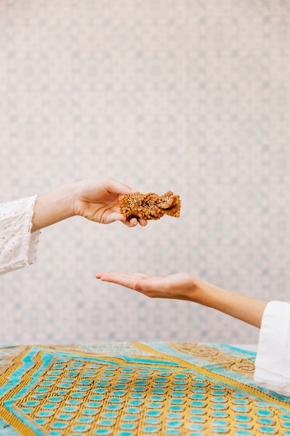 Foto gratuita mano che tiene la pasticceria araba