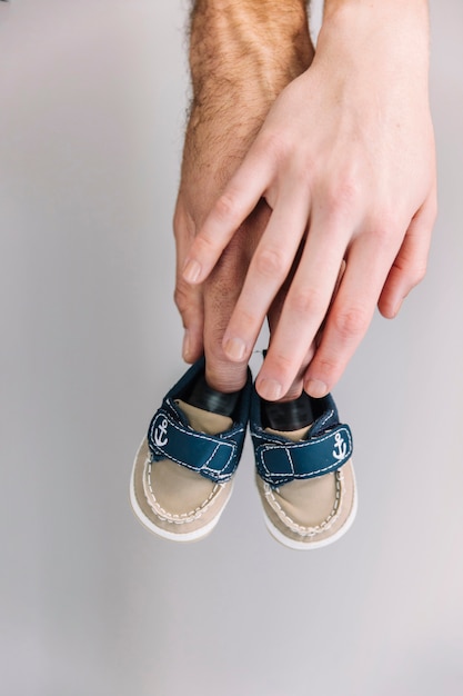 Free photo hand holding baby shoes