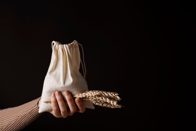 Hand holding bag and grains side view