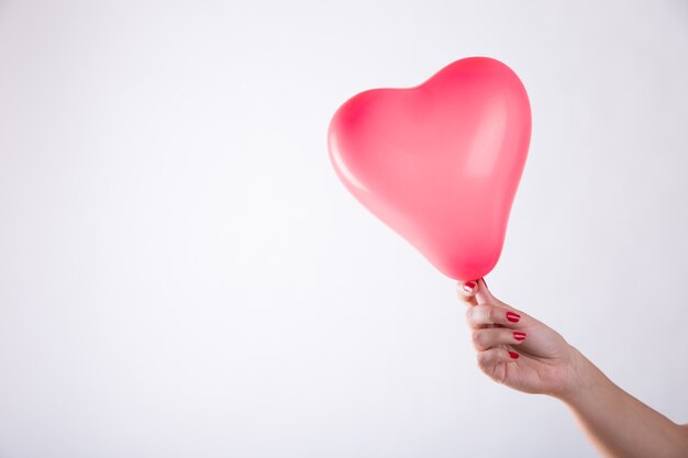 Рука с воздушным шариком в форме сердца