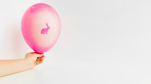 Free photo hand holding balloon with bunny