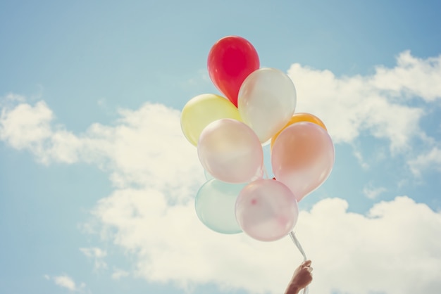 Hand holding balloons of different colors