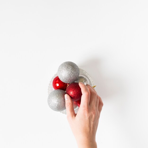 Hand holding baubles on table