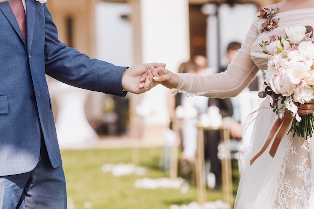 Free photo hand holding a beautiful wedding couple