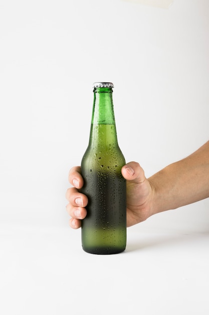 Free photo hand holding beer bottle