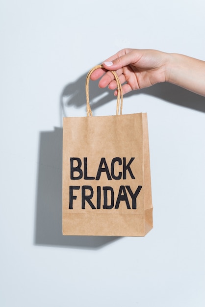 Free photo hand holding black friday paper bag