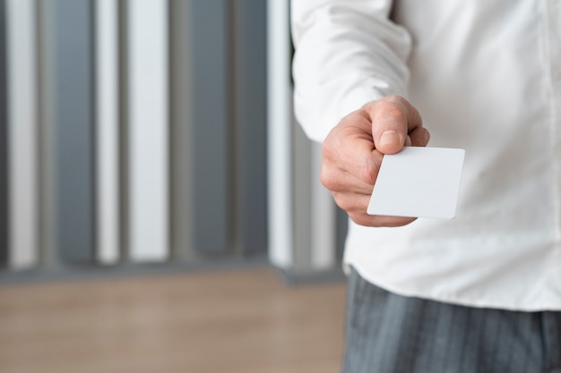 Hand holding blank business card high angle