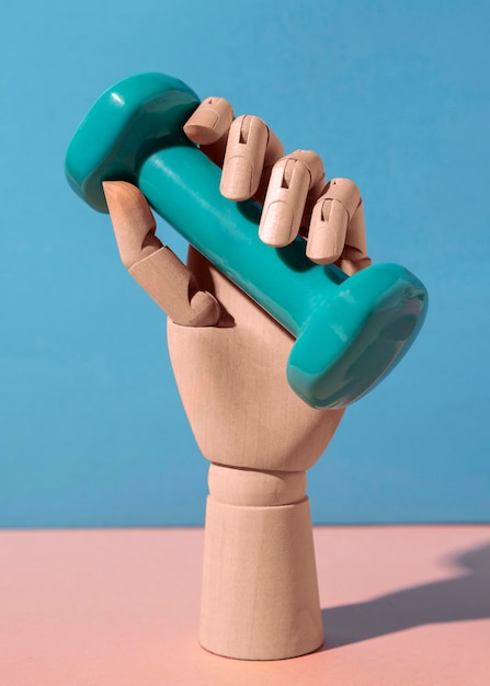 Free photo hand holding blue dumbbell still life