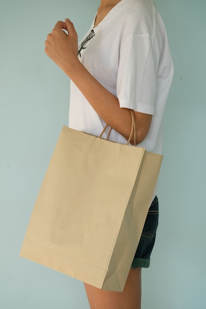 Free photo hand holding brown bag