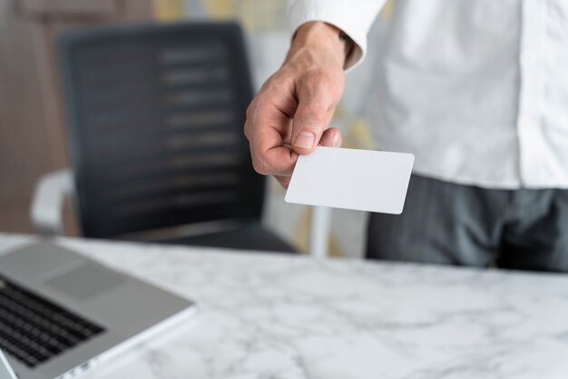 Free photo hand holding business card at desk high angle