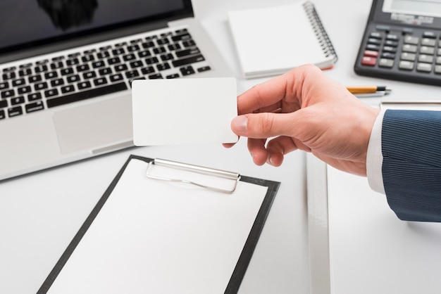 Free photo hand holding business card in office environment