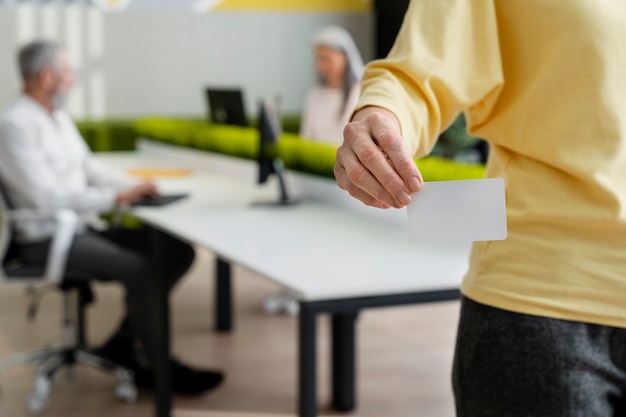 Free photo hand holding business card at office