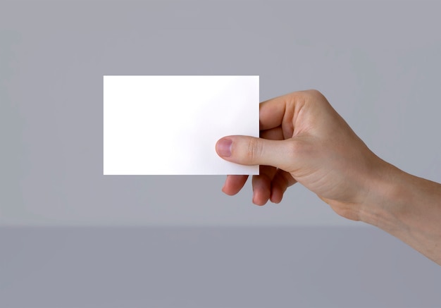 A hand holding a business card