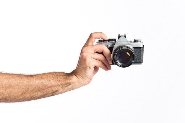 hand holding a camera over white background