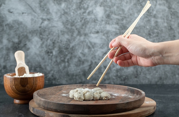 餃子と箸を持っている手。