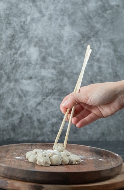 Free photo hand holding a chopstick with a dumpling