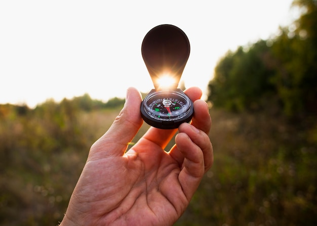 Free photo hand holding compass in the air