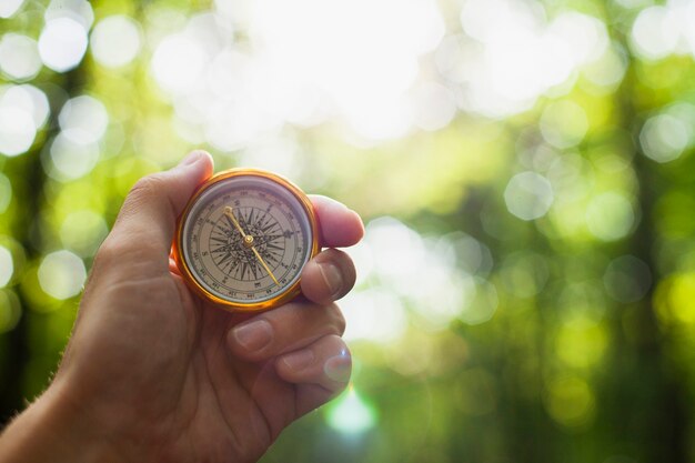 Hand holding a compass with blurred background