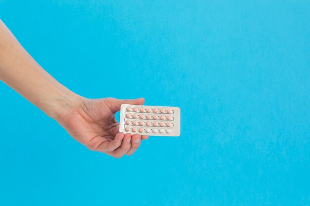 Hand holding contraceptive pills