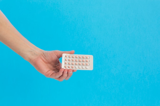 Hand holding contraceptive pills